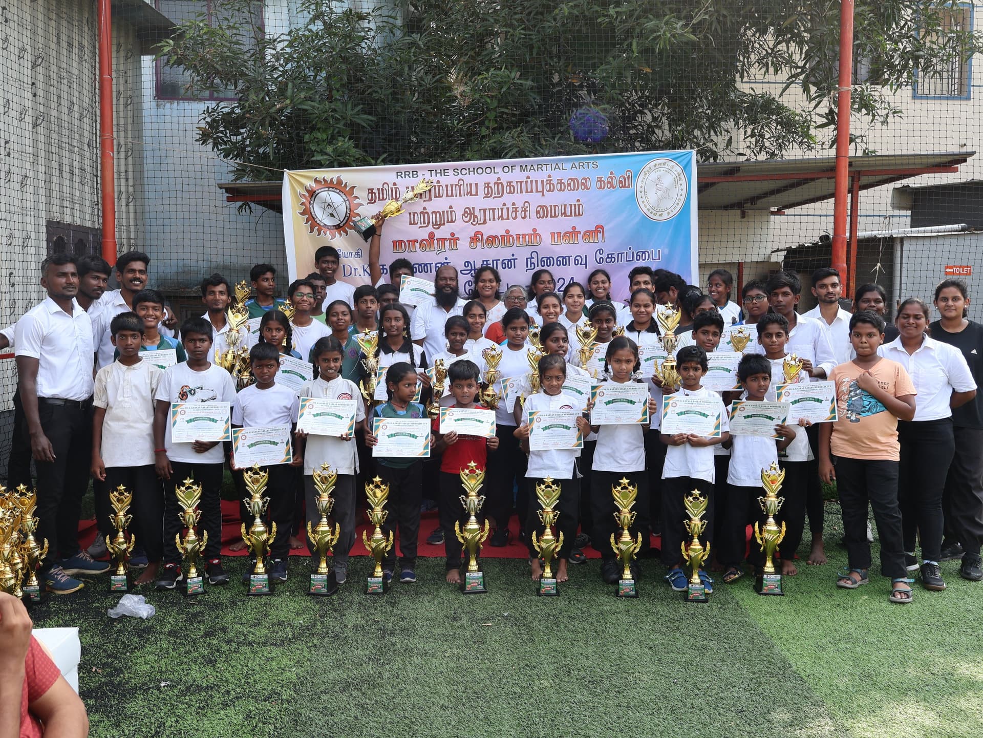 Tamil martial arts tournament participants group photo with trophies and medals