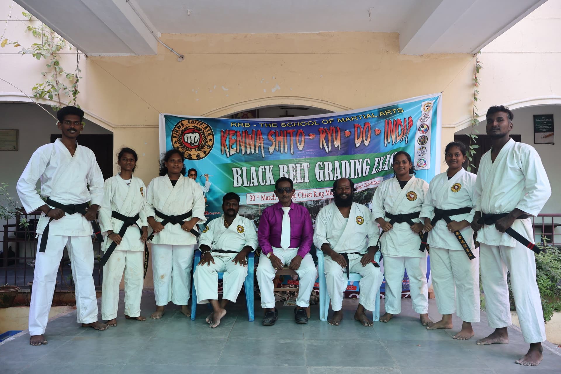 Martial arts instructor distributing certificates to karate students after belt examination