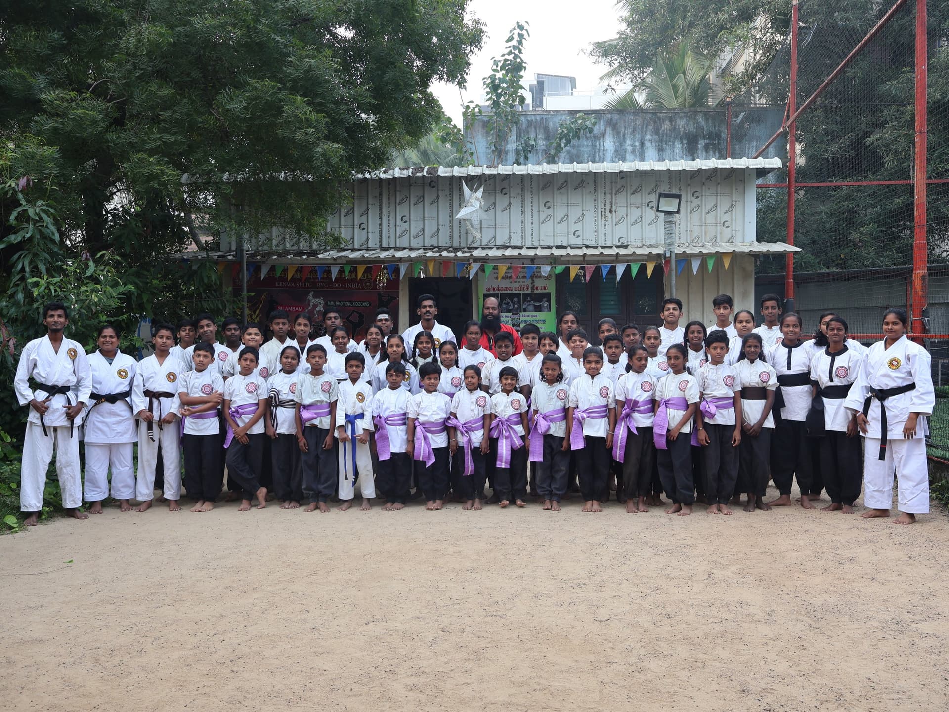 Large group of silambam martial arts students after successful belt grading ceremony