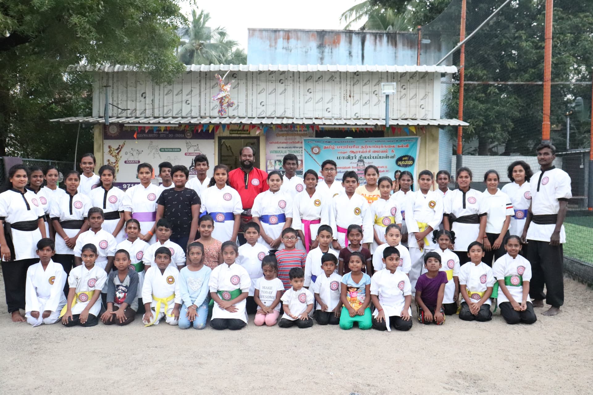 Silambam martial arts students group photo after belt examination with wooden staffs
