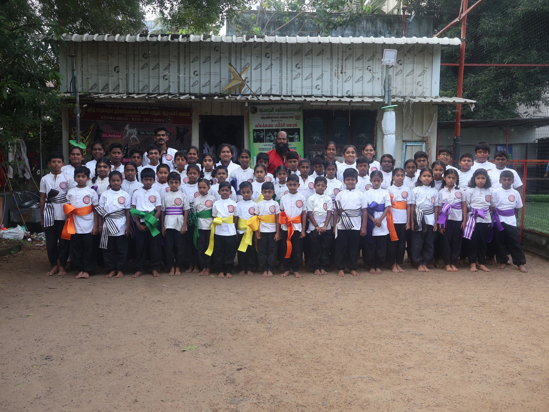 Evening silambam demonstration event with students performing staff fighting techniques