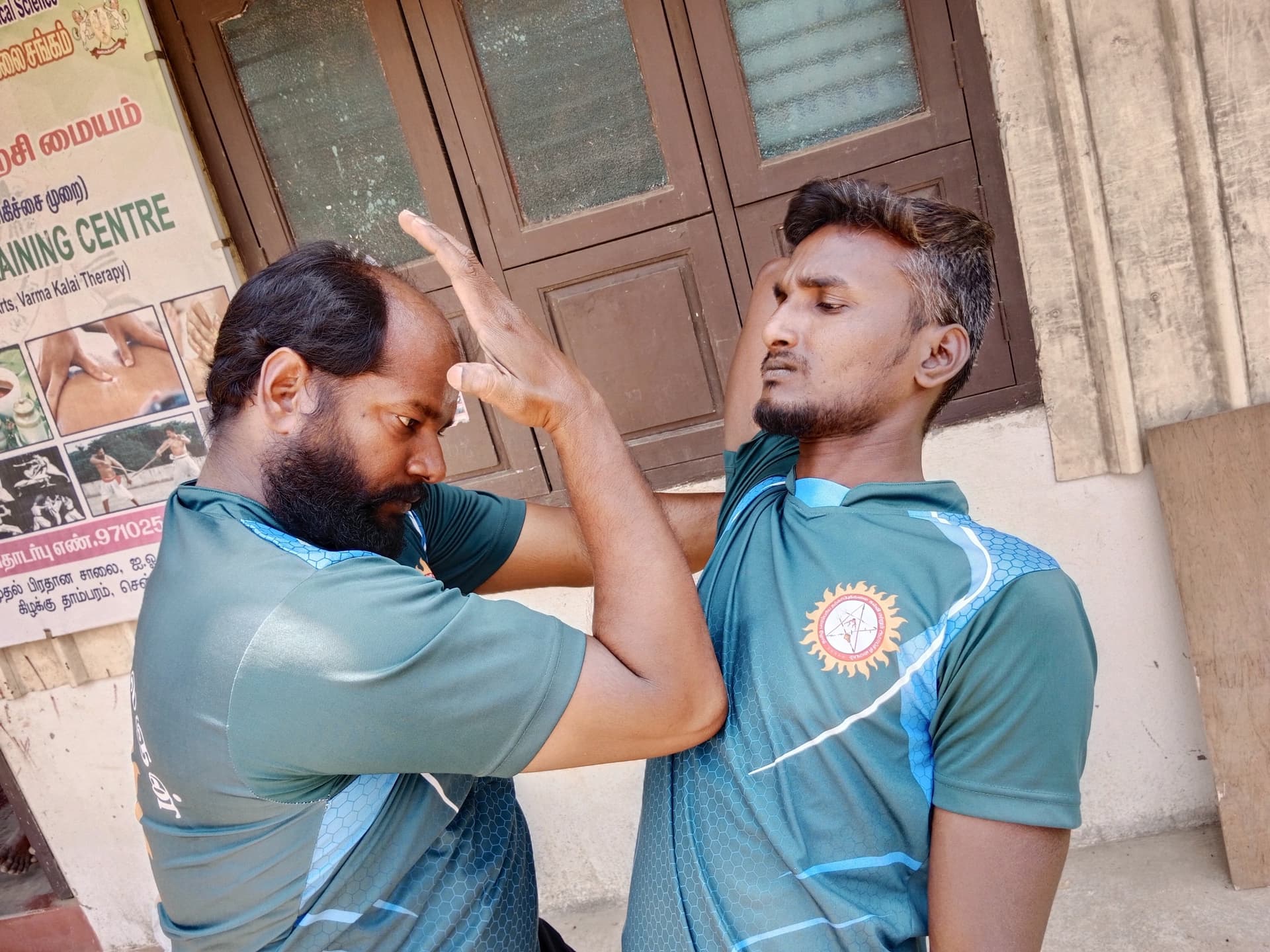 Group of martial arts students learning silambam staff movements in coordinated formation